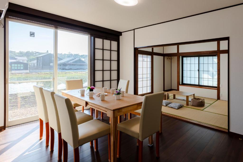 a dining room with a wooden table and chairs at NASU den-en in Nasu