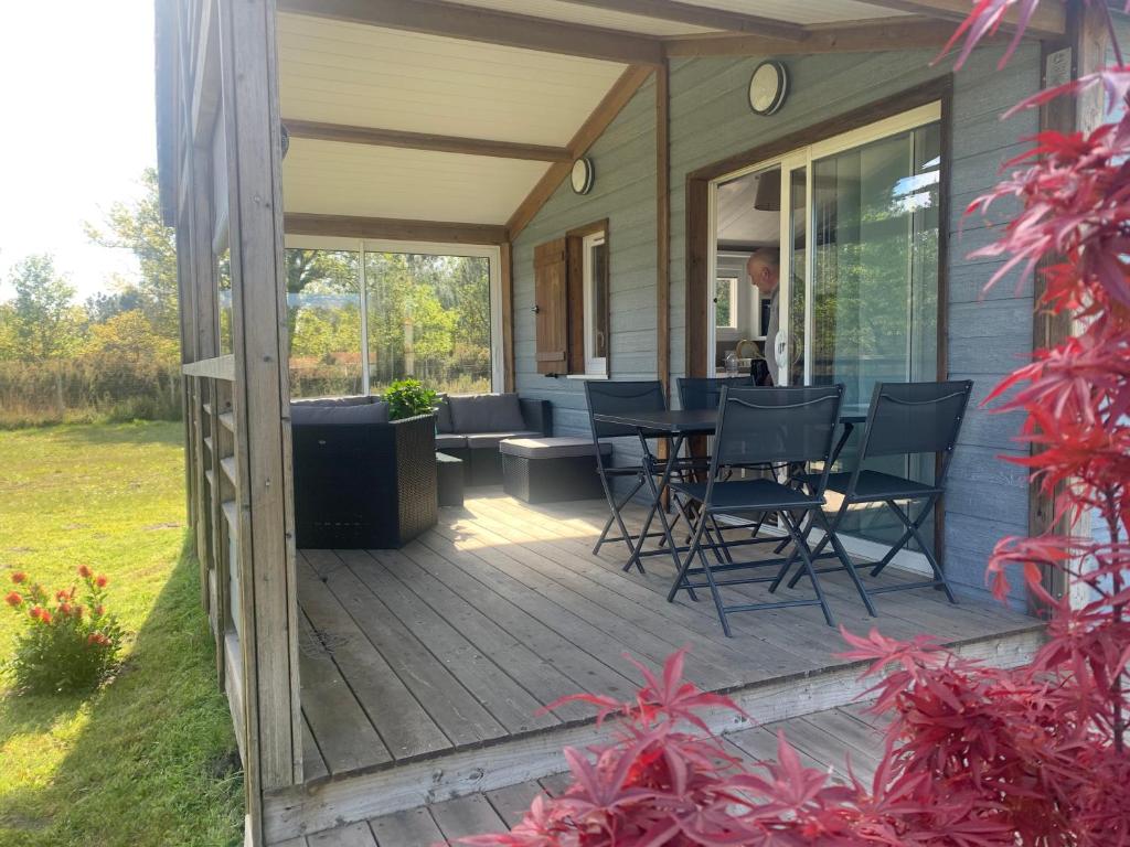 a deck with chairs and a table on a house at Chalet parc nature océan in Hourtin