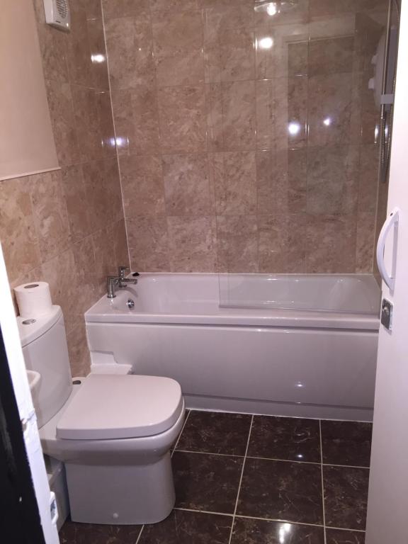 a bathroom with a toilet and a tub and a sink at Villa Bianca B&B in Penrith