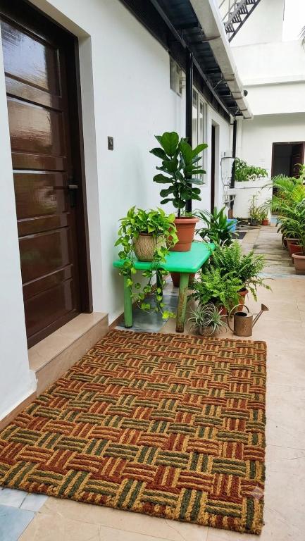 a rug in front of a door with a table and plants at Tranquil Tents in Trivandrum