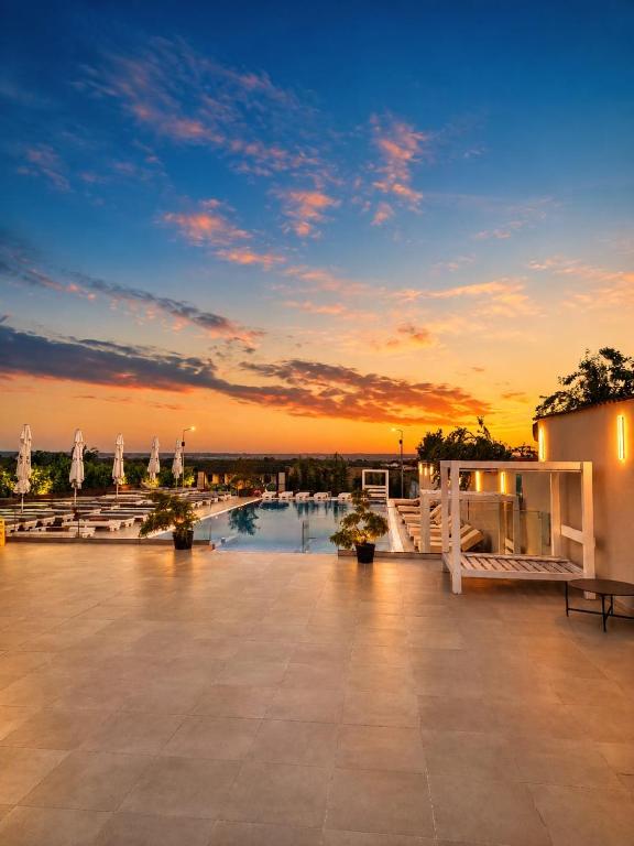 a patio with a sunset in the background at Hotel Goya Boutique in Târgu Jiu