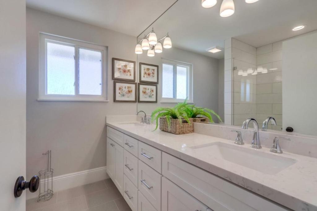 a bathroom with two sinks and a large mirror at Gorgeous Upgraded 5 Bedroom & 3 Bath Home with pool in Orange