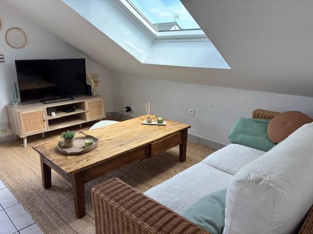 a living room with a couch and a table at Le Cocon Loire, 3-room apartment in La Ville-aux-Dames