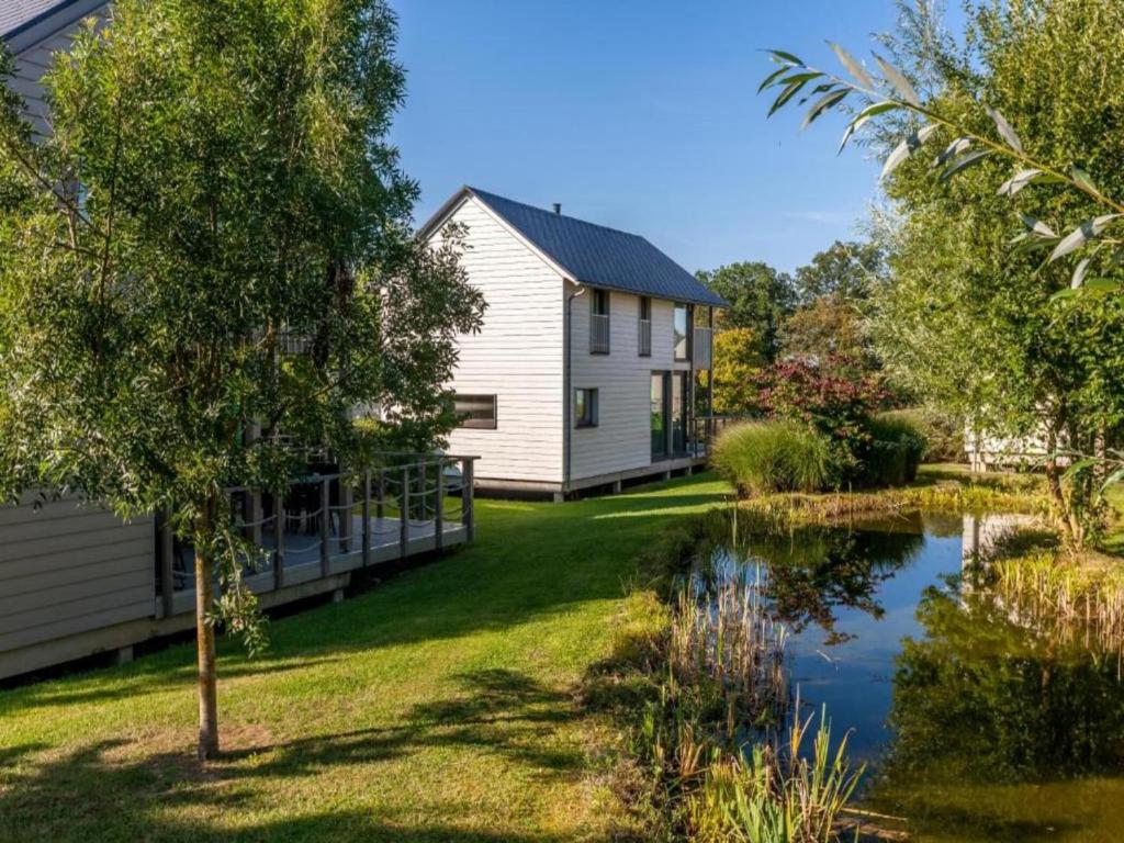 a house with a pond in the yard at Lakeside Stay with Sauna in Boussu-lez-Walcourt