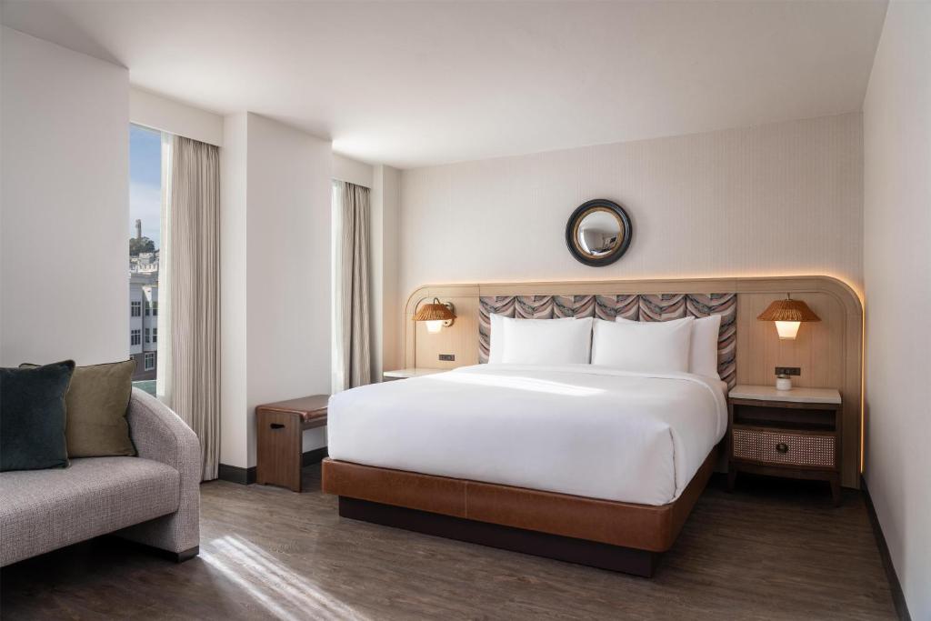 a bedroom with a large white bed and a couch at Hyatt Centric Fisherman's Wharf San Francisco in San Francisco