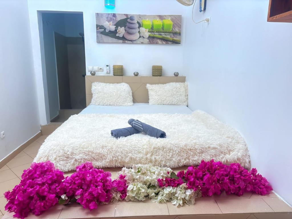 a bedroom with a bed with purple flowers on the floor at Hébergement H in Ngaring