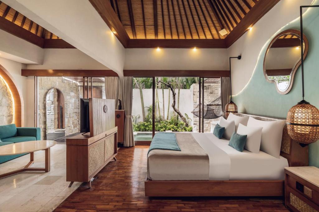 a bedroom with a bed and a desk and a television at Aksari Villa Seminyak by Ini Vie Hospitality in Seminyak