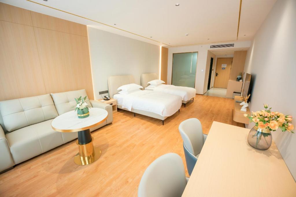 a hotel room with two beds and a couch at 玉恒酒店 in Sihui