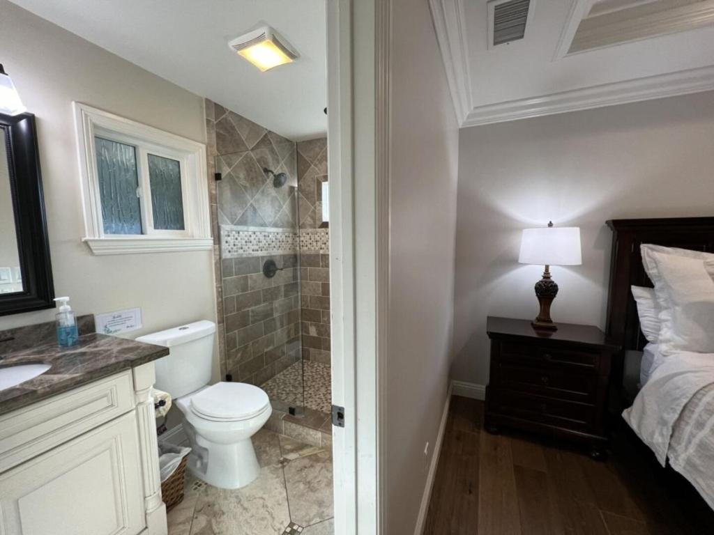 a white bathroom with a toilet and a shower at Fantastic 6 bedroom, 4 & Half bath home (4 master Suites), pool home in Anaheim