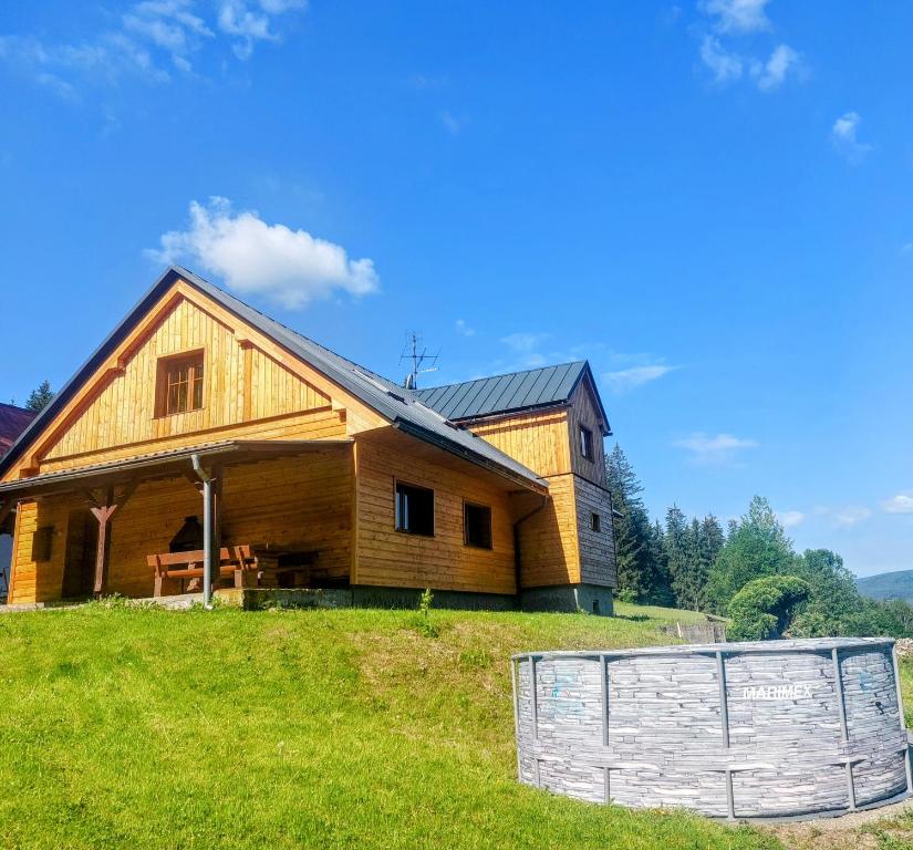 a large wooden house with a fence in front of it at Chalupa Pavlonka in Staré Hamry