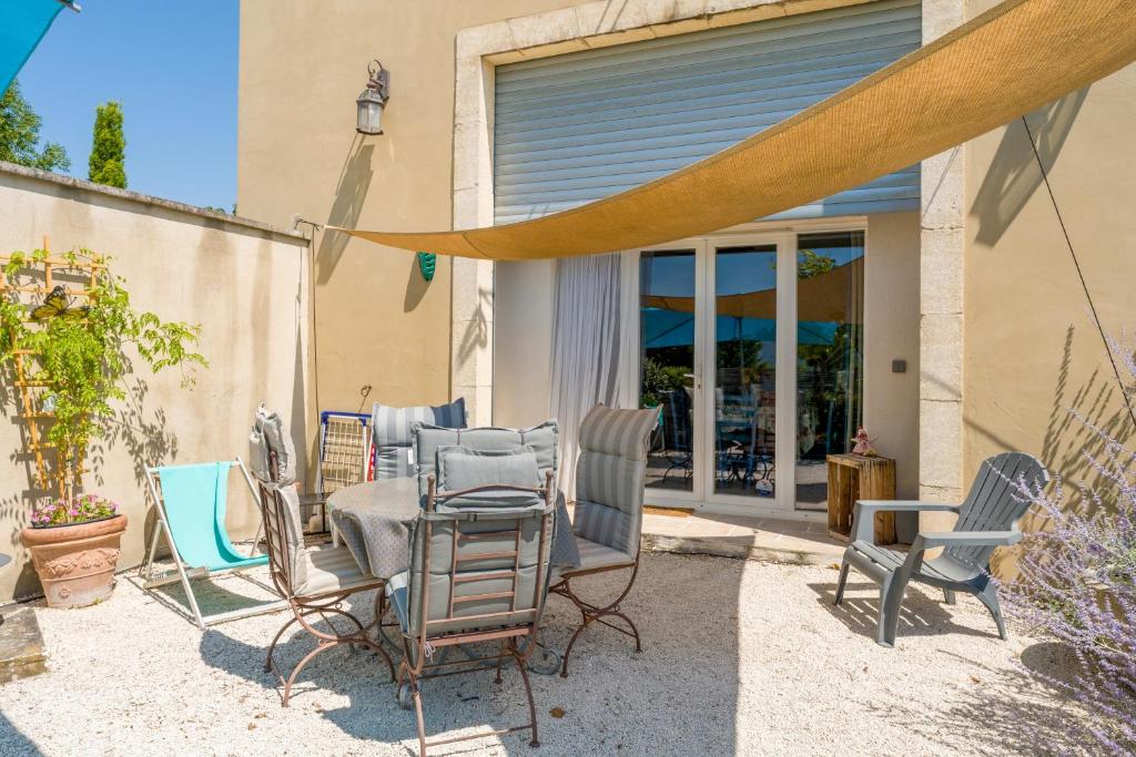 a patio with a bunch of chairs and a table at Gîte le Petit Luberon - Lisianthus in Cabrières-dʼAvignon