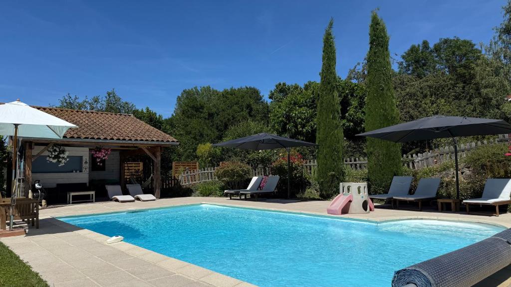 a swimming pool with chairs and umbrellas at Villa L'Hermitière - 4 étoiles in Oytier-Saint-Oblas