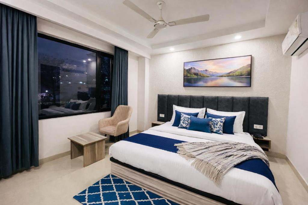 a bedroom with a bed and a large window at Hotel LA Costa Managed By Sitara Group in Haridwār