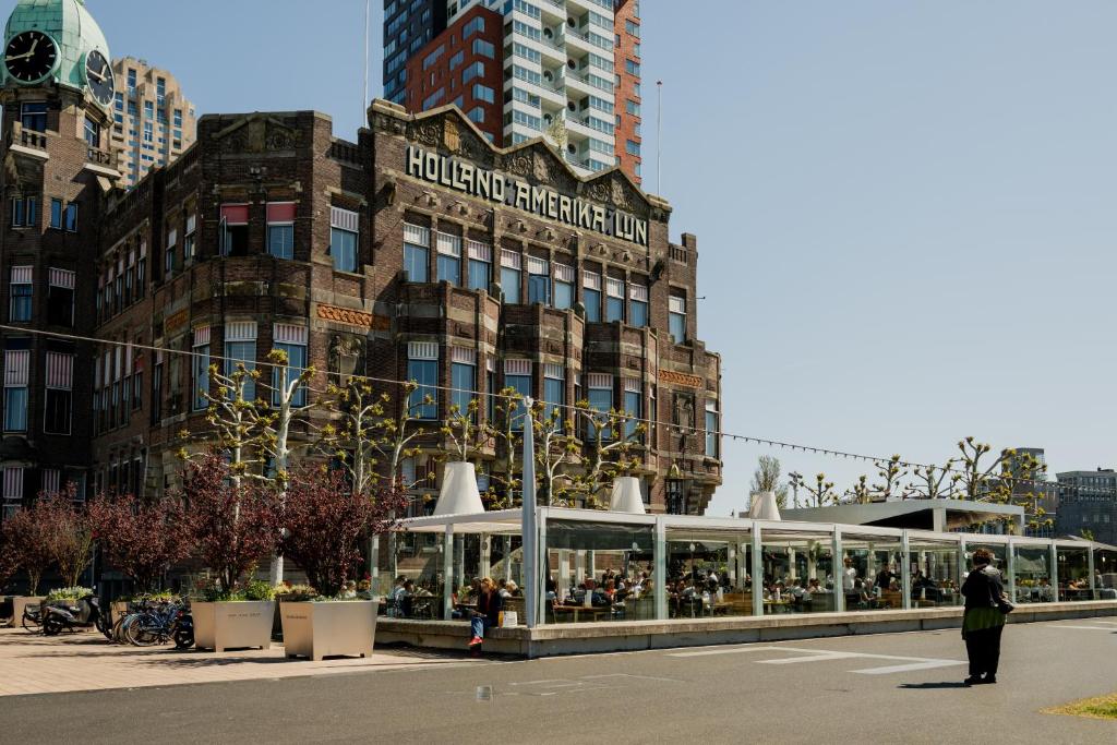 a building with a restaurant in front of it at Hotel New York by WestCord in Rotterdam