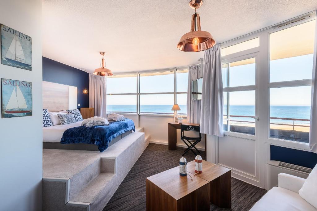 a bedroom with a bed and a view of the ocean at Baya Hotel in Capbreton