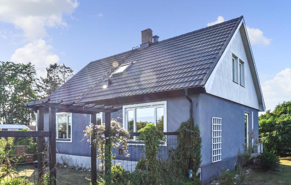 a blue house with a gambrel roof at 4 Bedroom Lovely Home In Simrishamn in Simrishamn