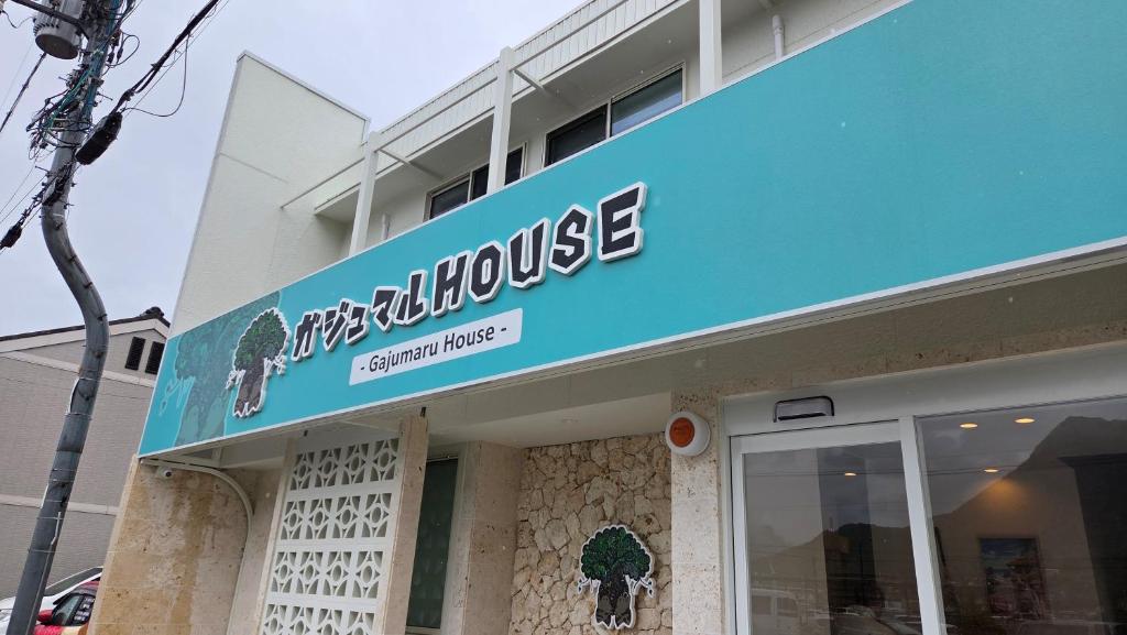 a store with a blue sign on top of it at ガジュマル House in Tonosho