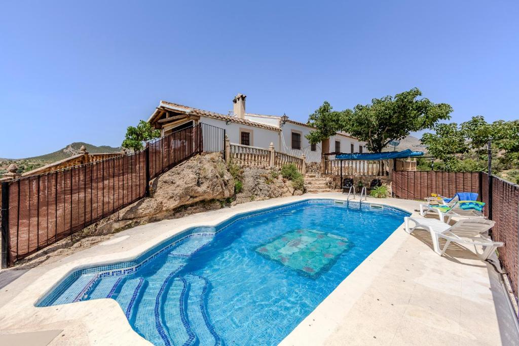 a swimming pool in front of a house at Casa Rural Cortijo Celdran in Vélez-Rubio