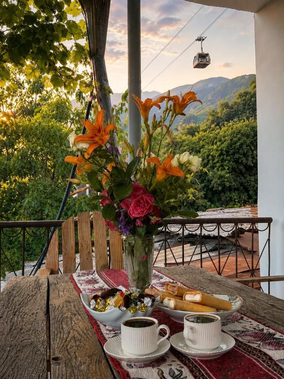 a table with a vase of flowers and plates of food at Narine Bed and Breakfast, Tour in Tatʼev
