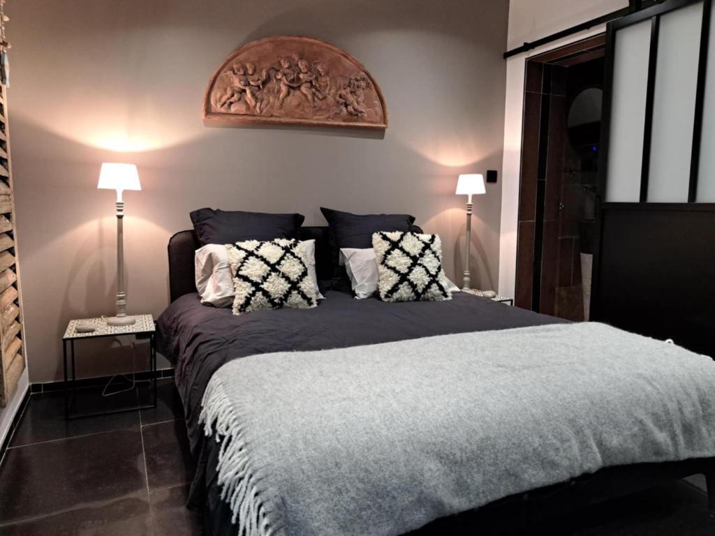 a bedroom with a large bed with two lamps at Le clos d'oli in Wamin