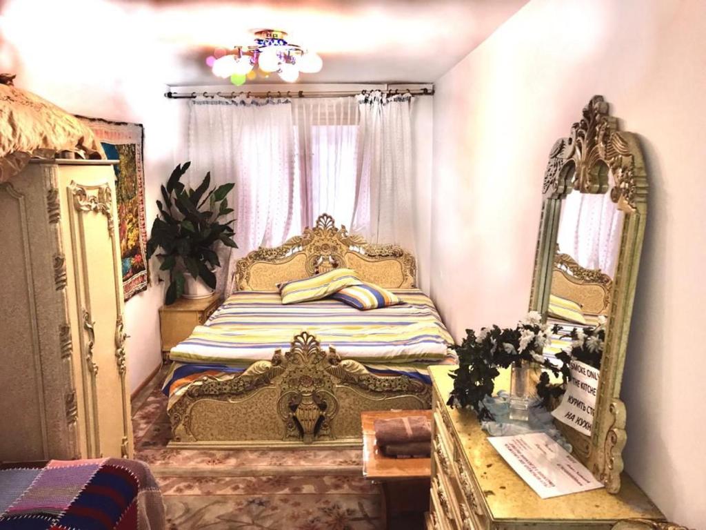 a bedroom with a gold bed with a mirror at Квартира 89 in Bishkek