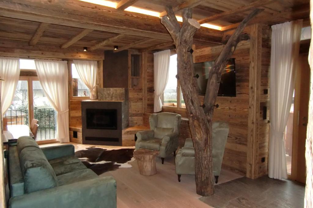 una sala de estar con un árbol en el medio en Neuprantl Apartments, en Lana