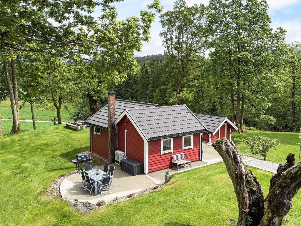 a red cabin in the middle of a yard at 4 person holiday home in OMASTRAND-By Traum in Sanddal