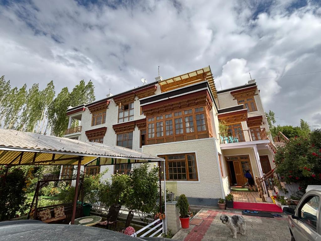 a house with a dog standing in front of it at Gangs-Shun Homestay in Leh
