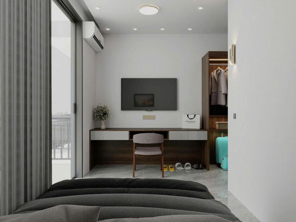 a bedroom with a bed and a tv on a wall at Olivia Hotel in Ấp Thành