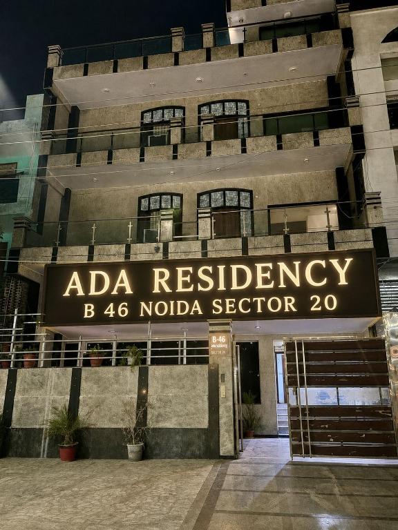 a building with a sign that reads ada residency b noida sector at ADA Residency in Noida