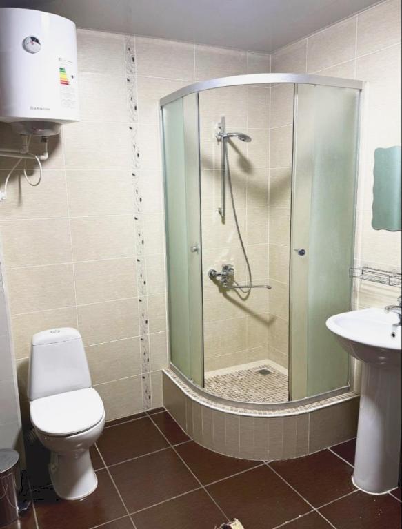 a bathroom with a shower with a toilet and a sink at Тихий дом in Fergana