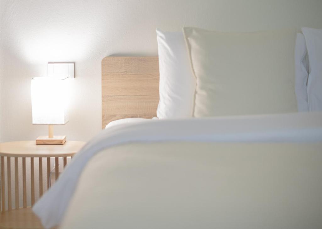 a bedroom with a bed and a lamp on a table at Quies Hotel in Krabi