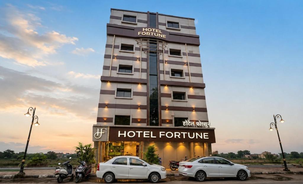 a hotel with two cars parked in front of it at Hotel Fortune in Mumbai