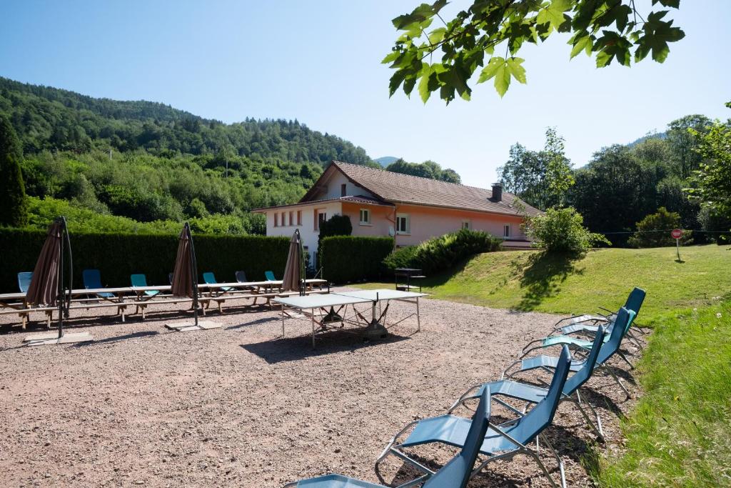 a group of chairs and a table and umbrellas at Les Sources - 30 personnes in Bussang