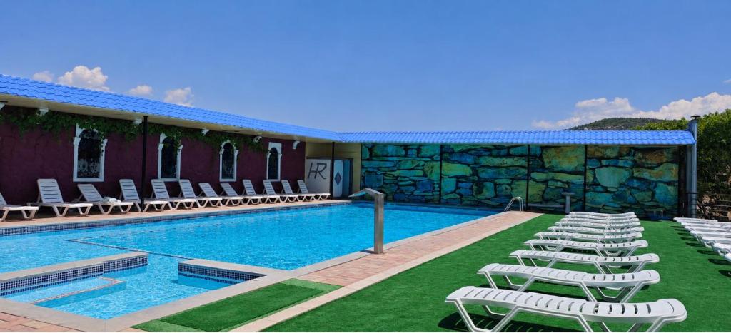 a swimming pool with lounge chairs next to a building at Canyon Hills Hotel in Yerevan