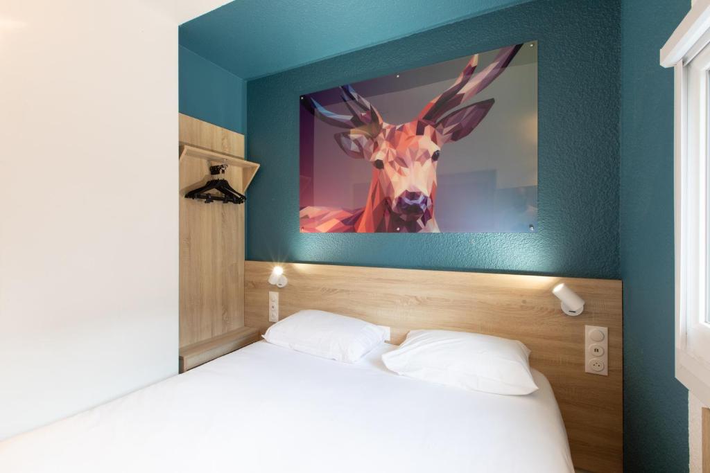 a bedroom with a picture of a deer on the wall at Kyriad ECO - Dijon Sud Chenove in Chenôve
