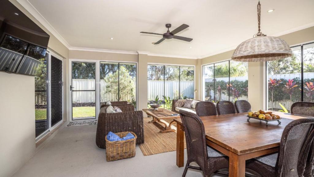 a dining room with a table and chairs at Blissful Birdsong Escape in Banksia Beach