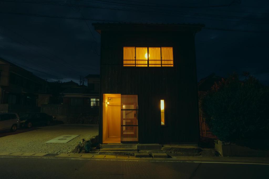a building with a door and two windows at night at 浬-kairi-1852 in Choshi
