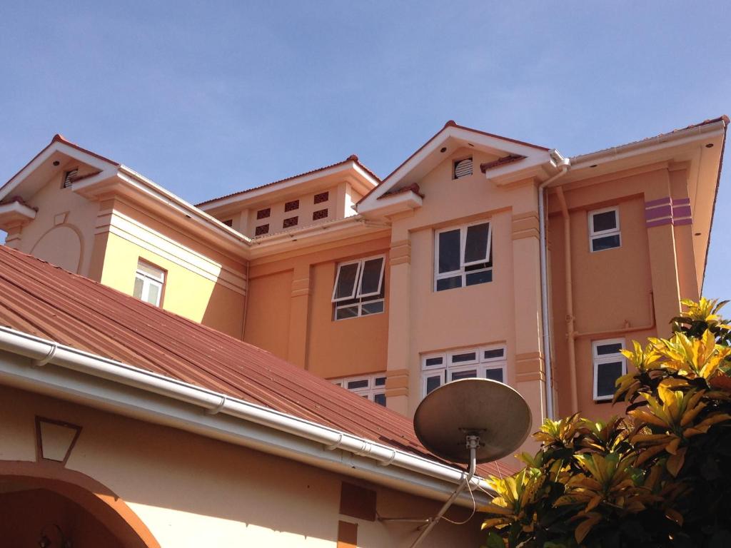 un bâtiment avec un toit et un satellite dans l'établissement J residence Motel, à Entebbe