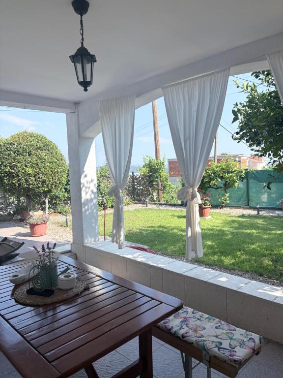a porch with a table and a view of a yard at Apartment Finally in Kastel Stari