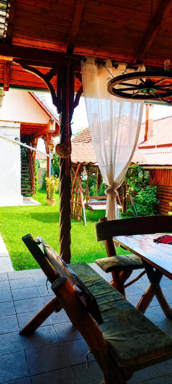 a patio with a table and a chair under an umbrella at Casa Marty in Cârțișoara