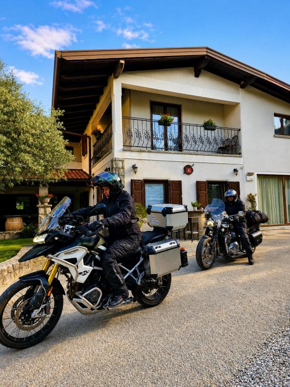 two people on motorcycles parked in front of a building at Pri Martinovih in Deskle