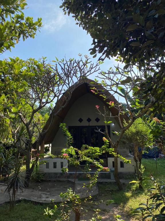 a small white building with a pointed roof at meno smile cottages 2 in Gili Meno