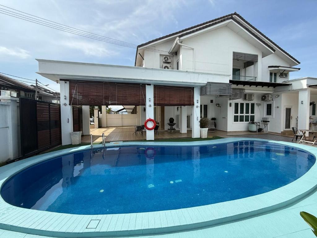 a large blue swimming pool in front of a house at Seri Botani Private Pool Villa 5BR in Ipoh