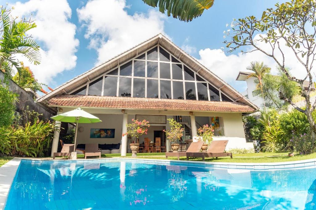 a house with a swimming pool in front of it at Villa Raquel by Betterplace in Seminyak