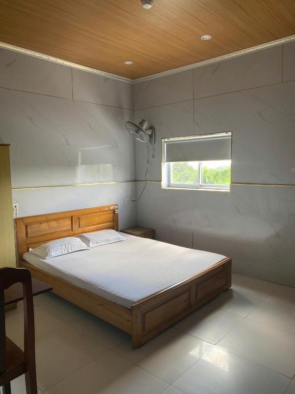 a bedroom with a bed in a room with a window at khách sạn gia bình in Xóm Miếu
