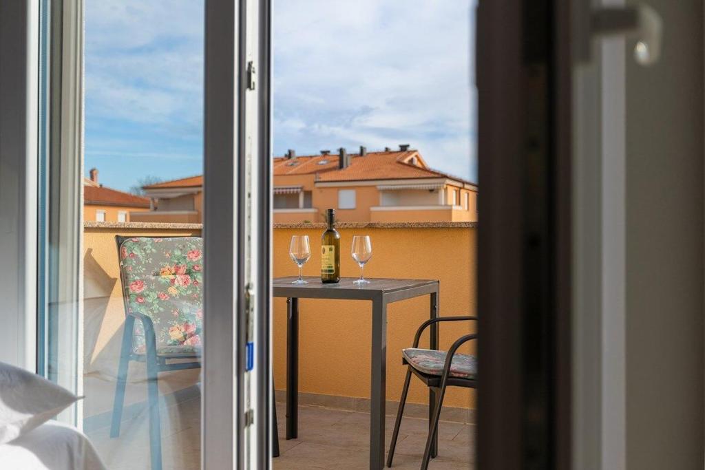 a balcony with a table with two glasses of wine at Apartment Vallera in Medulin