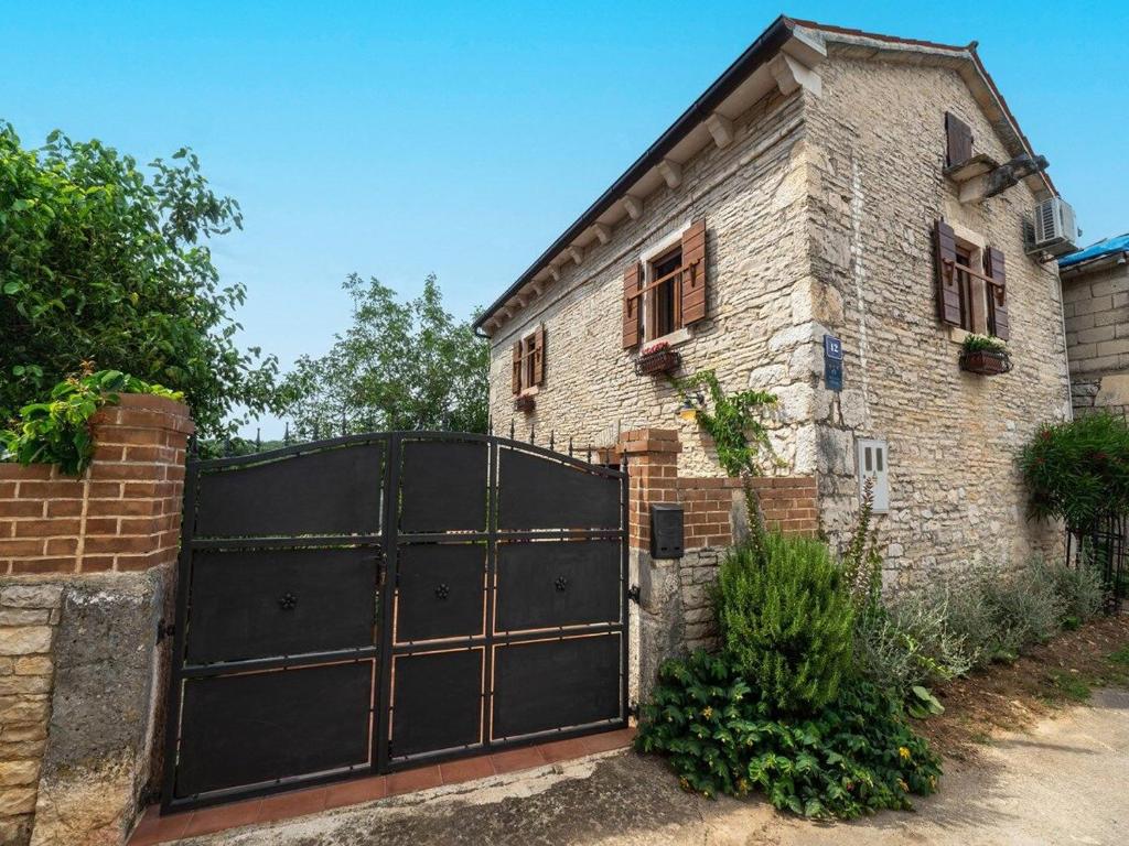 an old brick house with a black gate at House Luca in Barban