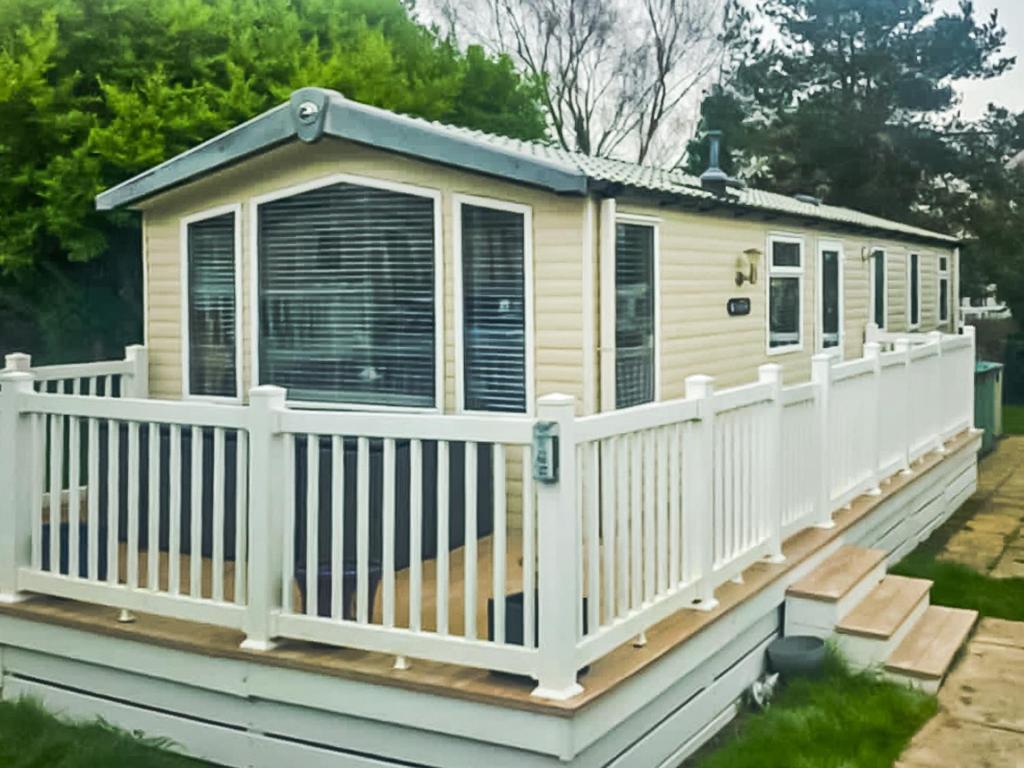 a house on a deck with a fence at 86 Cader Idris in Pwllheli