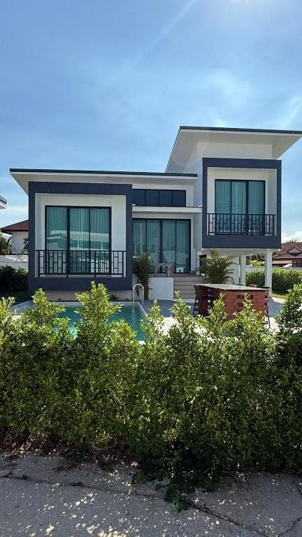 a house with a swimming pool in front of it at Pool Villa Maephim 34, by Somjai in Ban Tha Fat